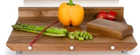 קרש חיתוך מעץ עם ירקות כולל אספרגוס, פלפל ועגבניות על רקע לבן