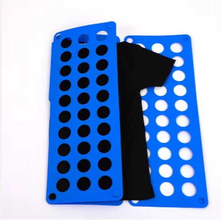 חולצה שחורה מקופלת חלקית בתוך מקפל חולצות על רקע לבן