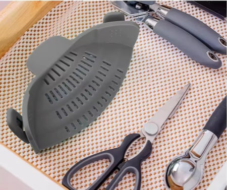 מסננת אפורה מונחת לצד מספריים